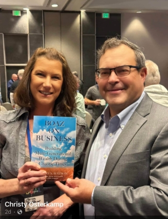 Female reader showing her copy of Boaz on Business book with Jeff Watson